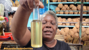 María Borja vendedora de coco en el mercado, con el aceite de coco.